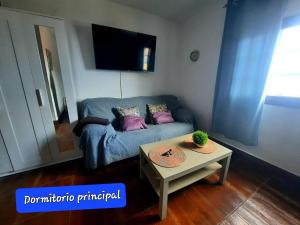 a living room with a blue couch and a table at Mi Parchita in Valverde