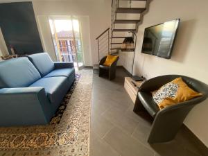 a living room with a blue couch and a chair at Penthouse Federico with lake view - Residenza Silvana in Verbania
