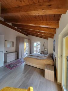 a bedroom with a large bed and wooden ceilings at Penthouse Federico with lake view - Residenza Silvana in Verbania