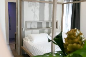 sypialnia z łóżkiem i lustrem w obiekcie Hotel Hollywood w Rimini