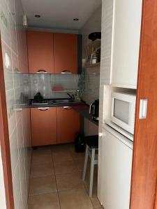 una piccola cucina con armadi arancioni e forno a microonde di Willa Mery a Zakopane