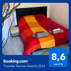 Una cama con un edredón colorido en un dormitorio en Grand f2 au calme centre de village, en Dampierre-les-Bois