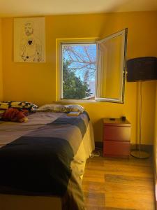 a yellow bedroom with a bed and a window at La casa di Judy e Frank in Tarquinia