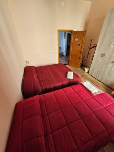 a bedroom with two red beds in a room at Affittacamere Pagoda RECANATI in Recanati