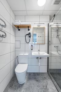 a white bathroom with a toilet and a sink at TopFloor Apartments in Vilnius