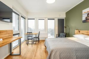 TopFloor Apartments في فيلنيوس: غرفة نوم بسرير وطاولة مع كراسي