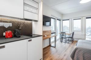 a kitchen with white cabinets and a table in a room at TopFloor Apartments in Vilnius