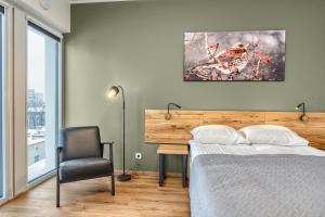 a bedroom with a bed and a desk and a chair at TopFloor Apartments in Vilnius