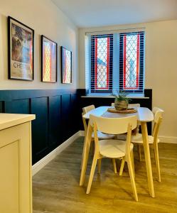 a dining room with a table and chairs and stained glass windows at Boutique Chapel Apartment within City Walls in Chester