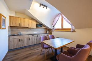 a kitchen with a wooden table and purple chairs at Hotel Neue Post in Zell am See