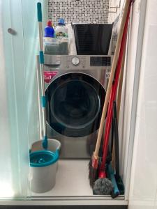 a washing machine with two mop and a broom at Daniel Cozy Flat Copa 1 - à 5min da praia in Rio de Janeiro