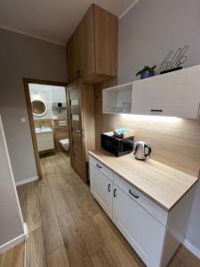 a kitchen with white cabinets and a counter top at Apartamenty Dobranocka in Krotoszyn