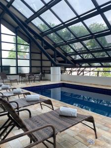 a swimming pool with chairs and a glass ceiling at Blue Tree Premium Paulista in Sao Paulo