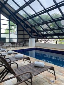 a swimming pool with chairs and a glass ceiling at Blue Tree Premium Paulista in São Paulo
