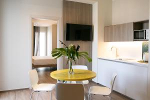 a kitchen with a table with a vase of flowers on it at Hotel Hollywood in Rimini