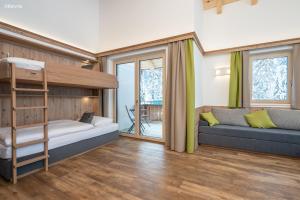 een slaapkamer met een stapelbed en een bank bij Appartements Salitererhof in Saalbach Hinterglemm