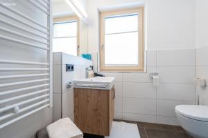 een badkamer met een wastafel en een toilet bij Appartements Salitererhof in Saalbach Hinterglemm +35 foto's