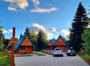 a car parked in front of some wooden buildings at Hedonist Village in Žabljak