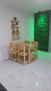a dining room table and chairs with a green wall at Flats Maracaipe in Porto De Galinhas