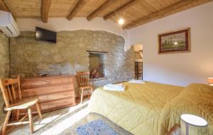 a bedroom with a bed and a stone wall at 1 Bedroom Lovely Apartment In San Piero Patti in San Piero Patti
