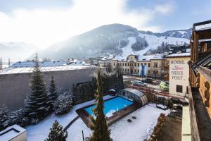 a resort with a swimming pool in the snow at Hotel Neue Post in Zell am See