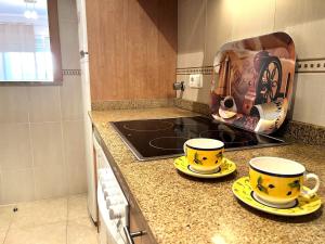 eine Küche mit zwei gelben Tassen und einem Toaster auf der Theke in der Unterkunft ACV - Torremar-2ª línea planta 1 norte in Oropesa del Mar