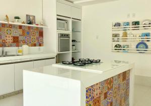 a kitchen with white cabinets and a stove top oven at Hospedagem Terraço Naturale in Domingos Martins