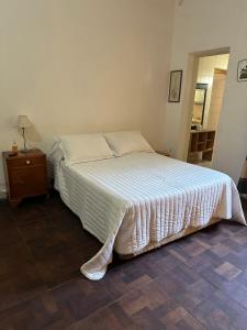 uma cama num quarto com uma mesa de cabeceira e uma cama sidx sidx sidx em Casa Los Rosales, amplia, cómoda, excelente ubicación con cochera em Puerto Madryn