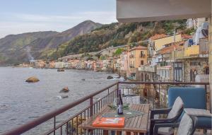 a balcony with a table and chairs next to the water at Amazing Apartment In Scilla With Wifi in Scilla