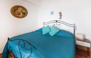 a bedroom with a blue bed with a picture on the wall at Amazing Apartment In Scilla With Wifi in Scilla