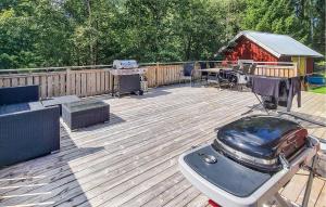 une grande terrasse en bois avec un grill et un grill dans l'établissement Gorgeous Home In Skepplanda With Private Swimming Pool, Can Be Inside Or Outside, à Skepplanda
