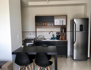 a kitchen with a stainless steel refrigerator and black counters at Central, próximo ao HCAA e Calçadão in Santa Maria +29 photos