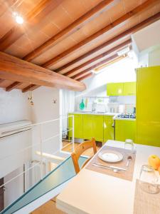 a kitchen with green cabinets and a table and chairs at Casa Giulia - Appartamento a San Gimignano in San Gimignano