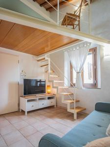 a living room with a staircase and a television at Casa Giulia - Appartamento a San Gimignano in San Gimignano