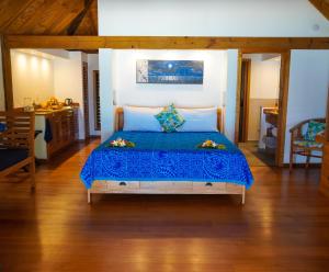 1 dormitorio con 1 cama con colcha azul en Heaven to Sea Beach Villas, en Amuri