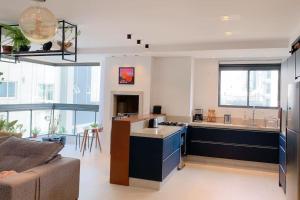 eine Küche und ein Wohnzimmer mit einem Sofa in der Unterkunft Luxuoso apartamento com vista mar em Itapema SC in Itapema