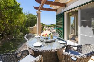 patio con tavolo e sedie sotto il portico di Vale De Lobo Villa With Pool by Homing a Vale do Lobo