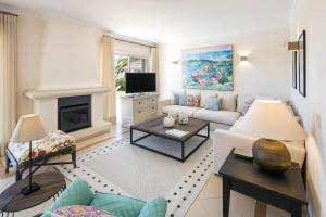 a living room with a couch and a fireplace at Vale De Lobo Villa With Pool by Homing in Vale do Lobo