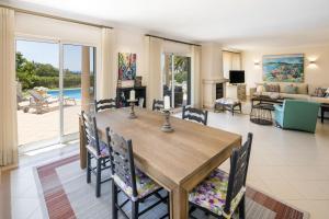 a dining room with a table and chairs and a living room at Vale De Lobo Villa With Pool by Homing in Vale do Lobo