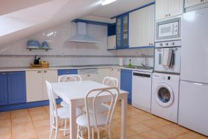 uma cozinha com armários azuis e brancos e uma mesa e cadeiras em El Deseo de la Vega em El Burgo de Osma