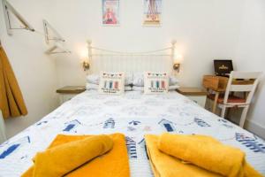 1 dormitorio con 1 cama con 2 toallas en Hendon Street Beach Huts en Brighton & Hove