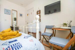 1 dormitorio con 1 cama y 1 mesa con sillas en Hendon Street Beach Huts en Brighton & Hove