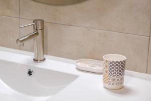 a cup sitting on a sink in a bathroom at El Deseo de la Vega in El Burgo de Osma