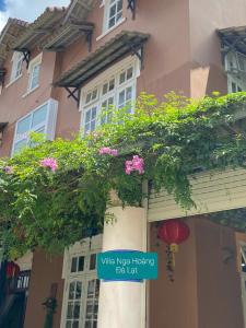 a sign in front of a building with flowers at villa Nga Hoàng Đà lạt in Da Lat