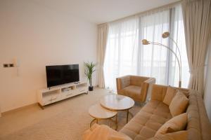 a living room with a couch and a tv at We are 25 Mins to Downtown Dubai in Ḩiz̧āyib az Zānah