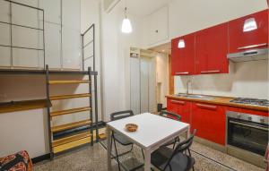 kuchnia z czerwonymi szafkami i białym stołem w obiekcie Amazing Apartment In Genova With Wifi w Genui