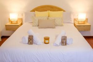 Una cama blanca con toallas y velas. en El Deseo de la Vega, en El Burgo de Osma