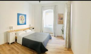 a white bedroom with a bed and a window at Lilli's Home in Ascoli Piceno