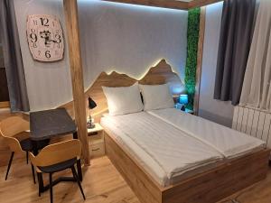 a bedroom with a bed and a clock on the wall at Aparthotel Vucko Jahorina NEW 451 in Jahorina