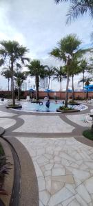 a courtyard with palm trees and a swimming pool at KL MARIGOLD APARTMENT At TIMES SQUARE in Kuala Lumpur